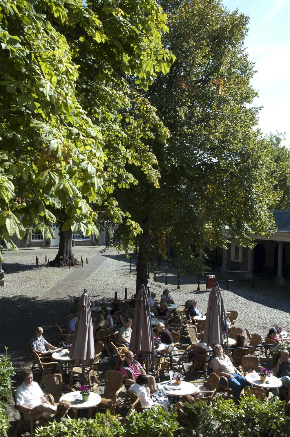 Het terras van Sint John onder de linden en kastanjes op de Vismarkt