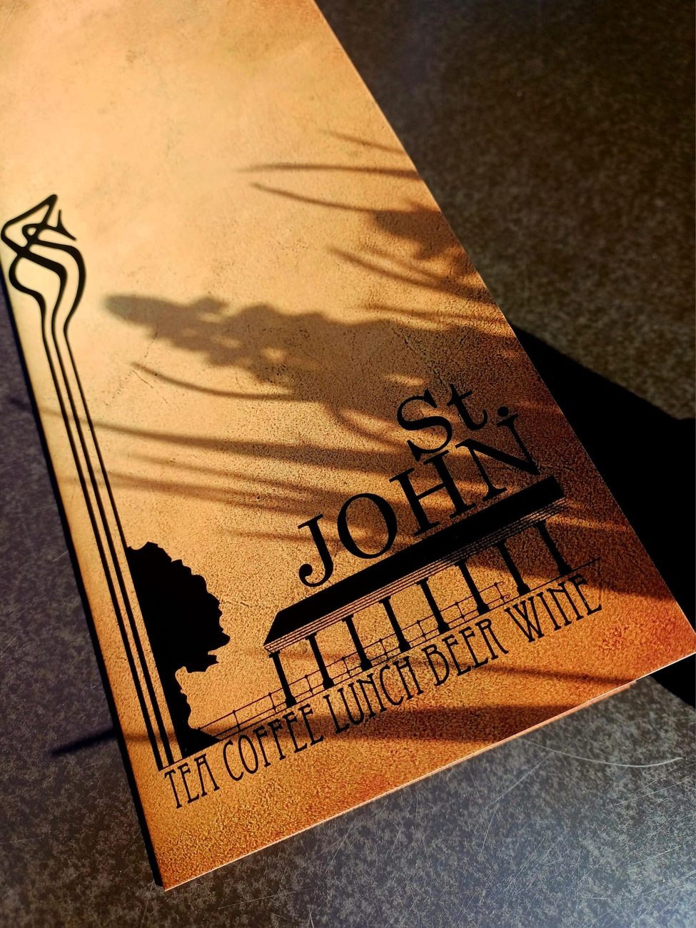 De schaduw van het uithangbord van St. John op de tafel